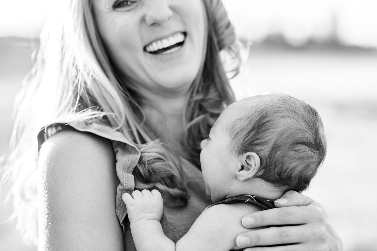 Black and white portrait of tender moment between parent and baby.