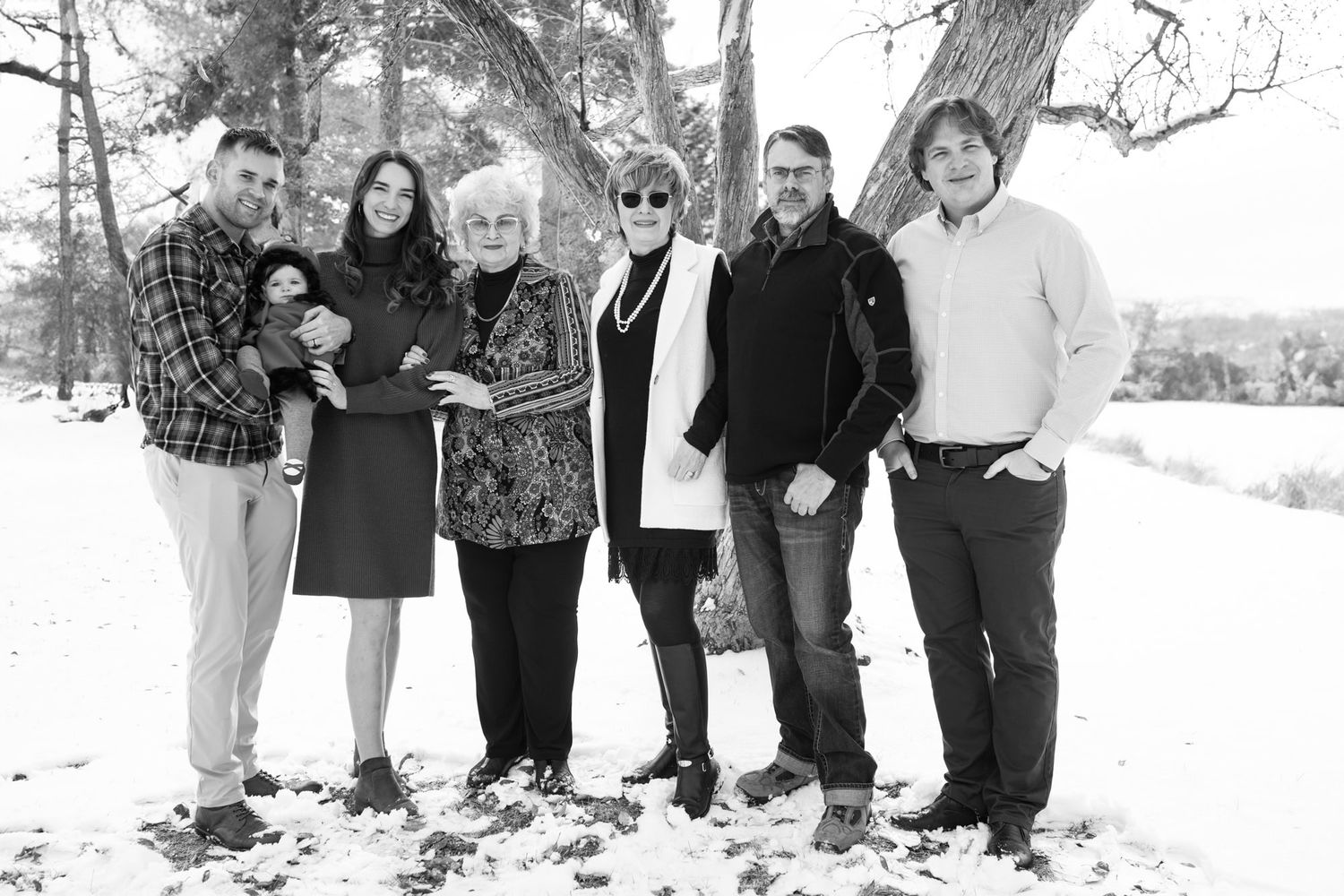 A family group portrait in black and white on a snowy winter day.