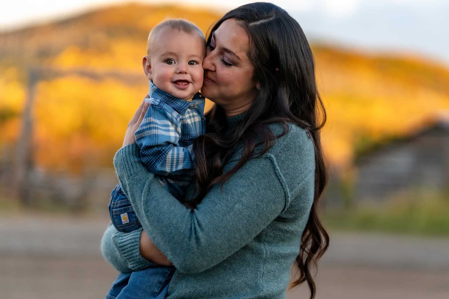 Sweet moment between parent and child with autumn mountain backdrop.