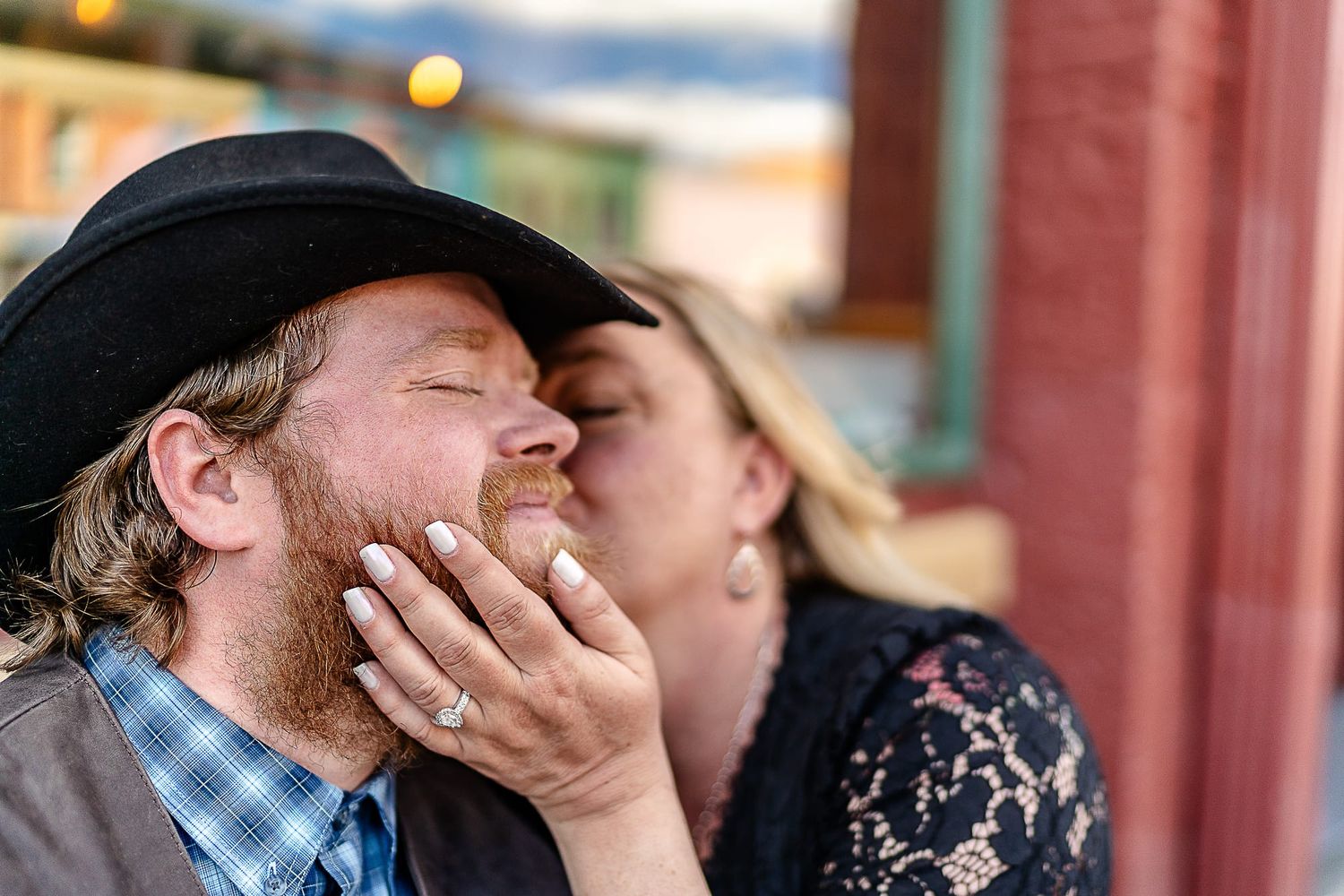 Candid moment of affection shared between couple on small town street.
