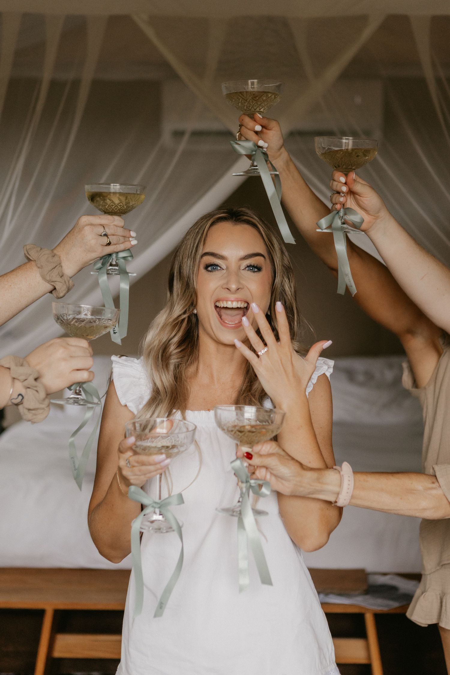 A series of four photos showing champagne glasses clinking together in celebration at a wedding reception.