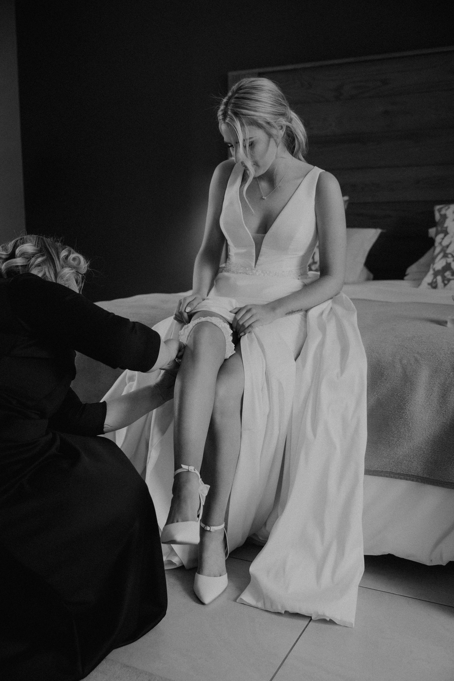 A black and white artistic photo series shows someone sitting on a bed in a white dress with lace details.