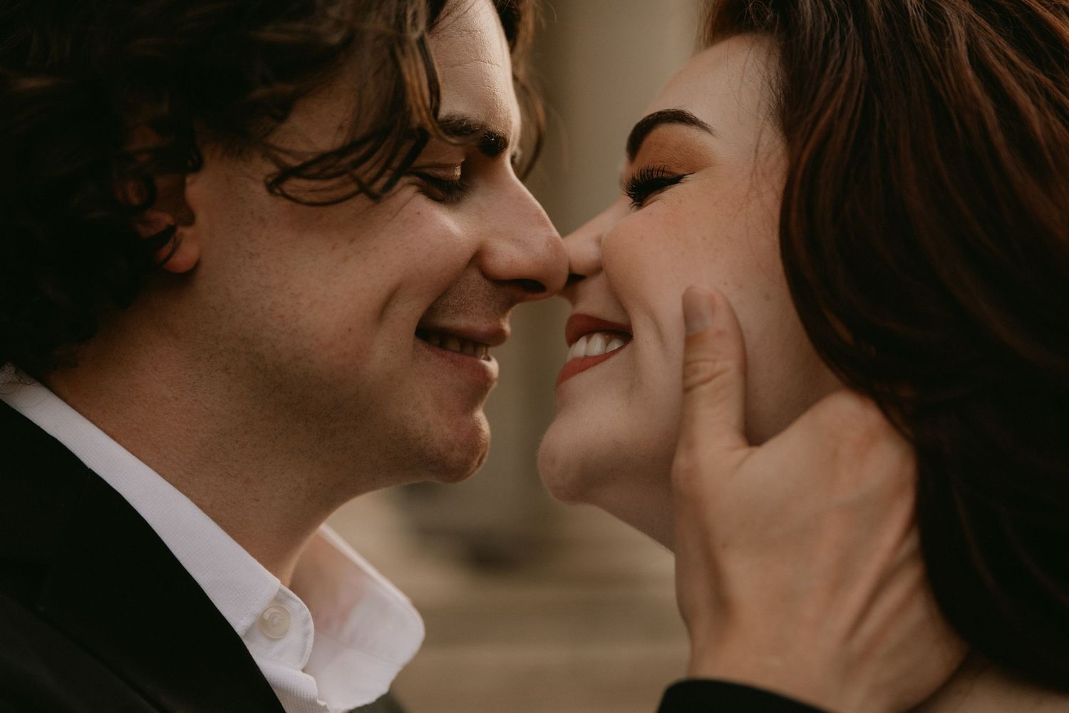 A romantic couple shares an intimate moment together in warm lighting.