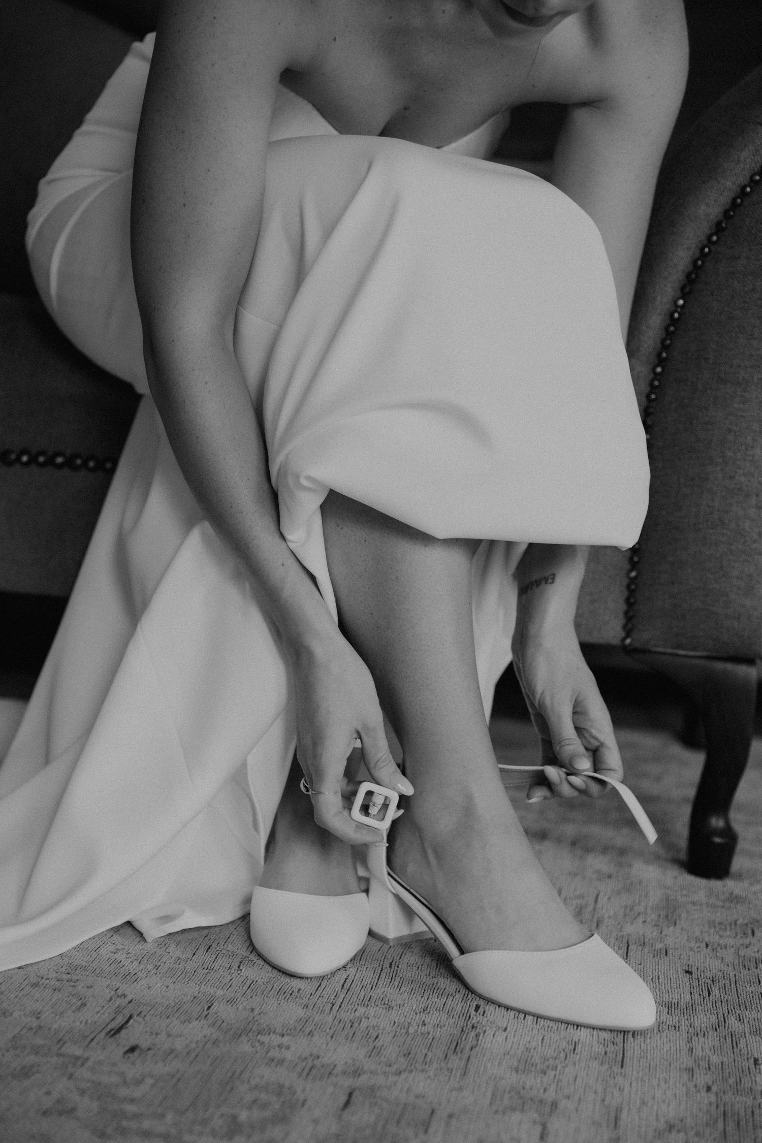 Black and white closeup sequence shows elegant wedding dress hem and bare feet against textured flooring.