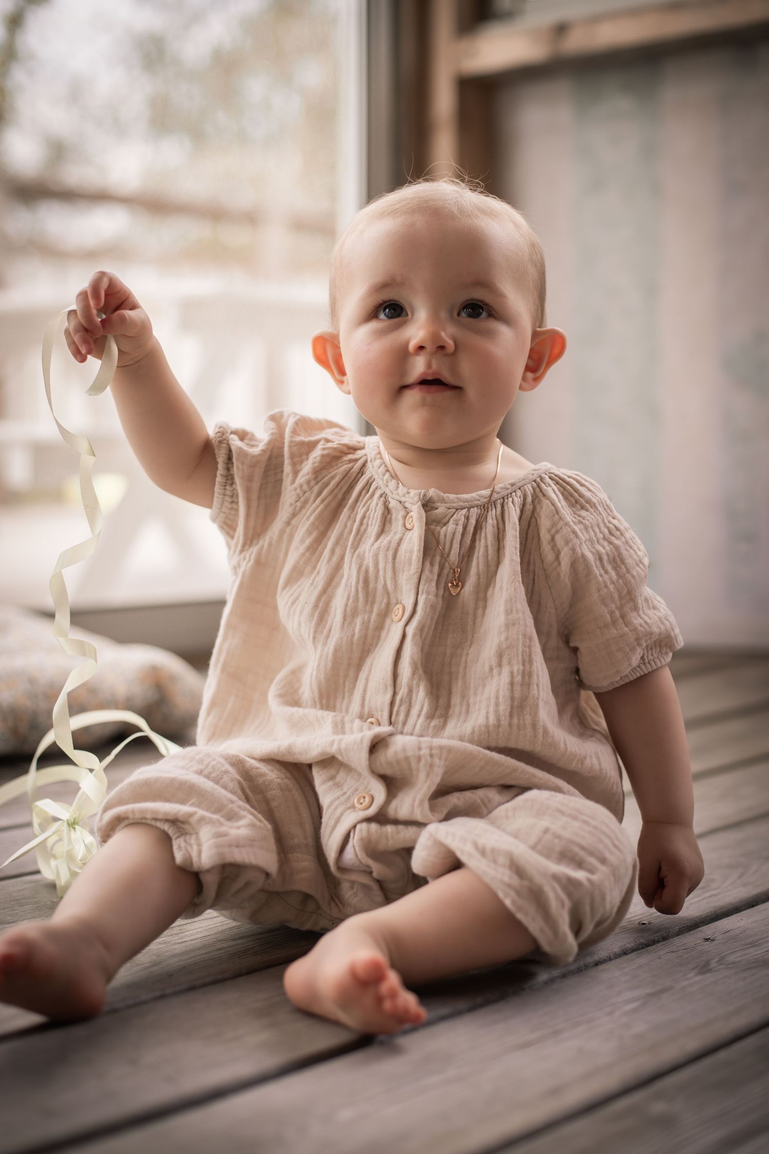 Porträtt av baby inomhus i mjukt fönsterljus - stilren och varm barnfotografering i Varnum.