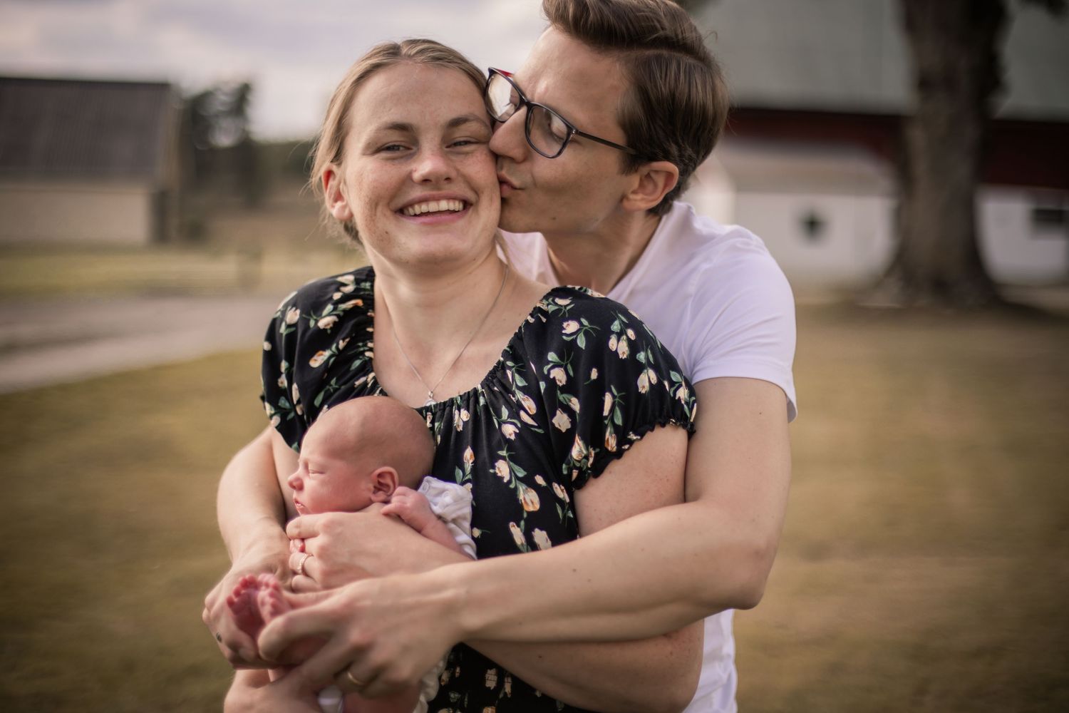 Föräldrar som håller sitt barn i en varm och naturlig bild i Varnum.