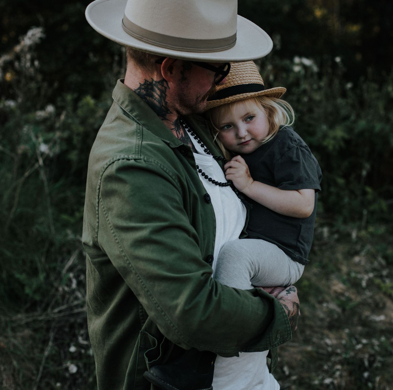 Närbild på pappa och dotter porträttfotografering i naturligt ljus och varm utomhusbild.