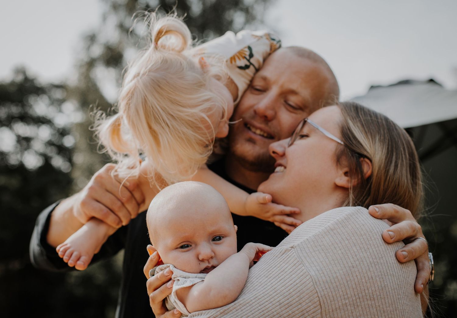 Kärleksfull. familj som kramas i Varnum, Västra Götaland - varm och naturlig familjefotografering utomhus.