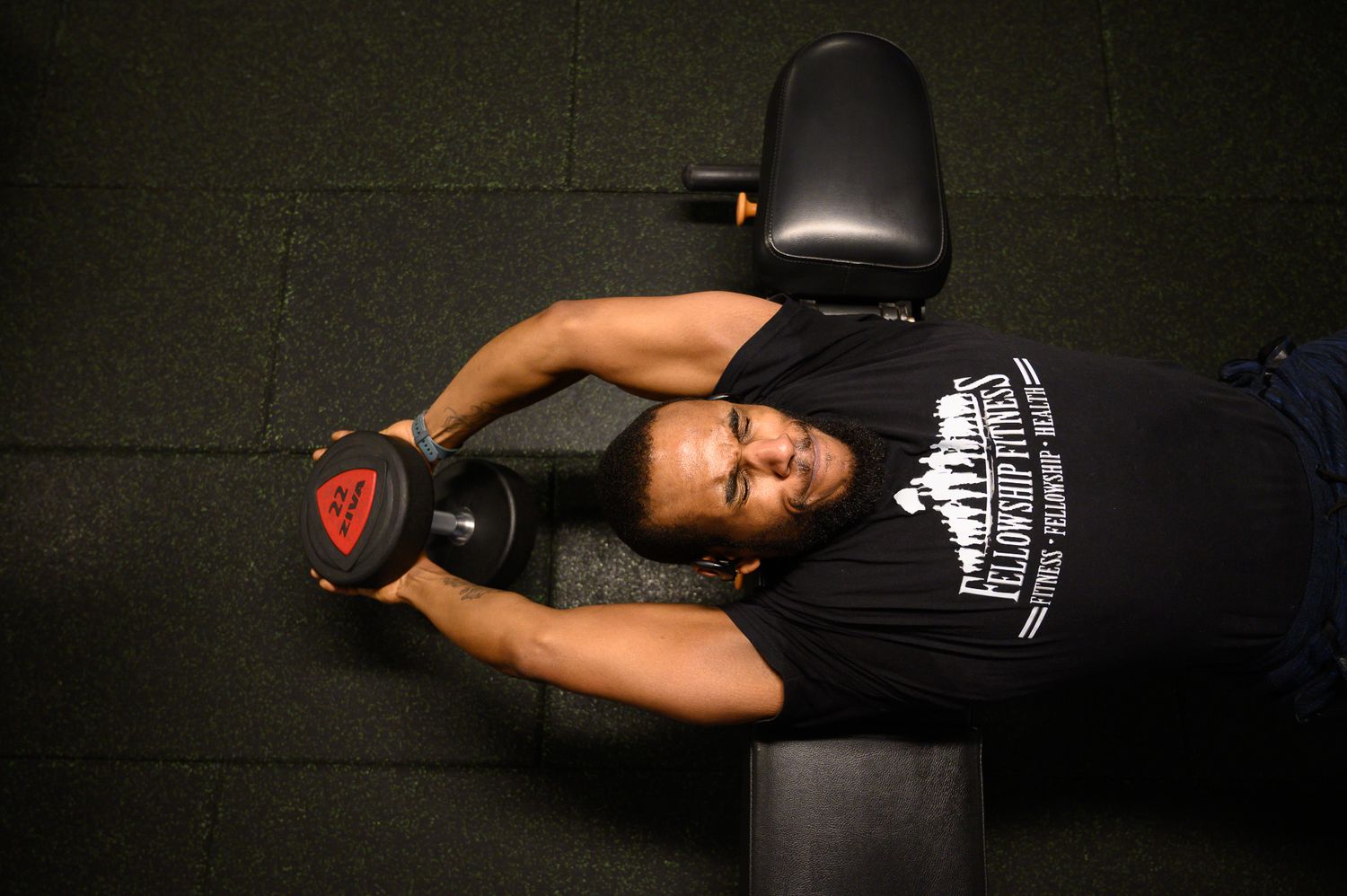 Overhead view of person exercising on workout bench at gym.