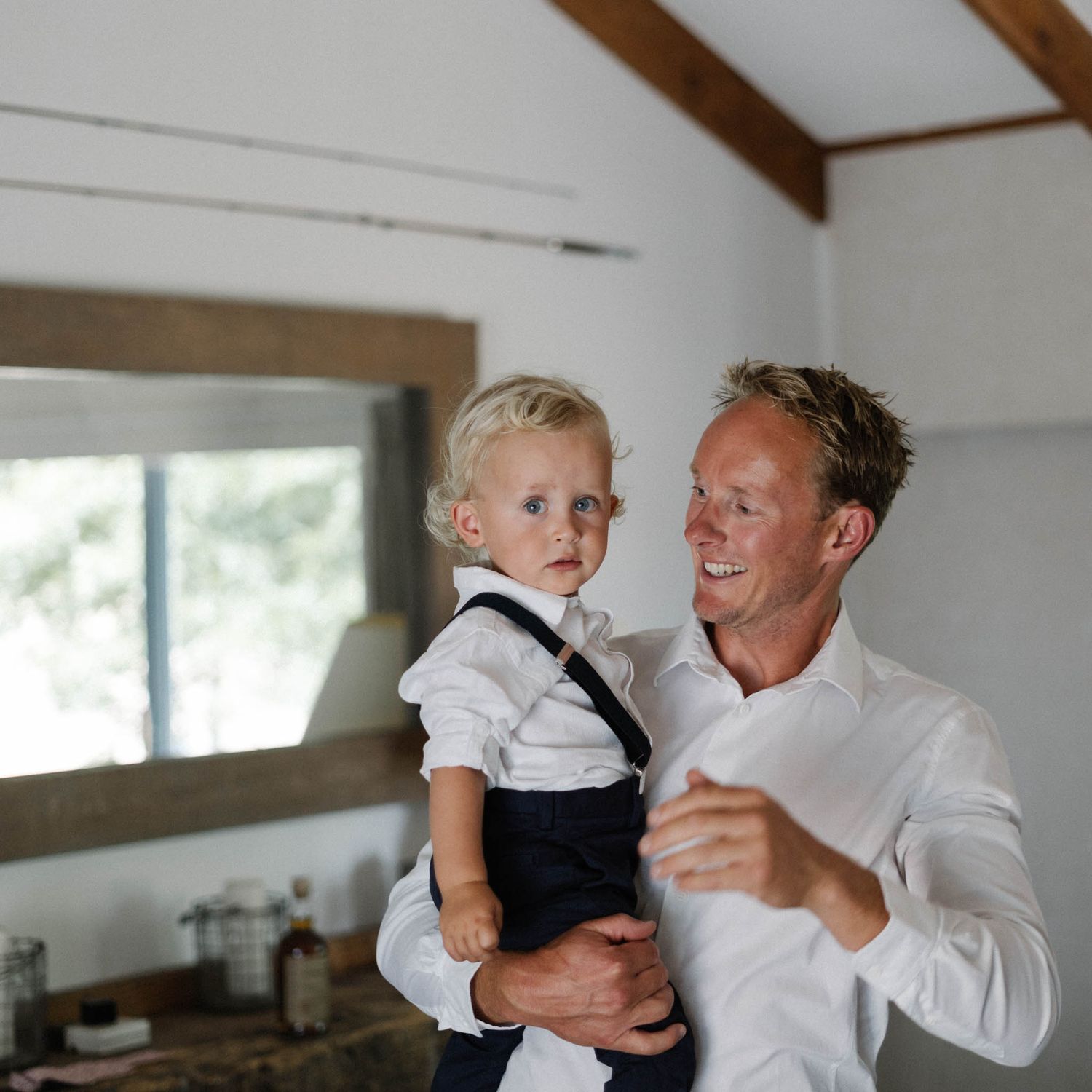 A sequence of candid moments showing parent and young child playing together indoors in a white room.