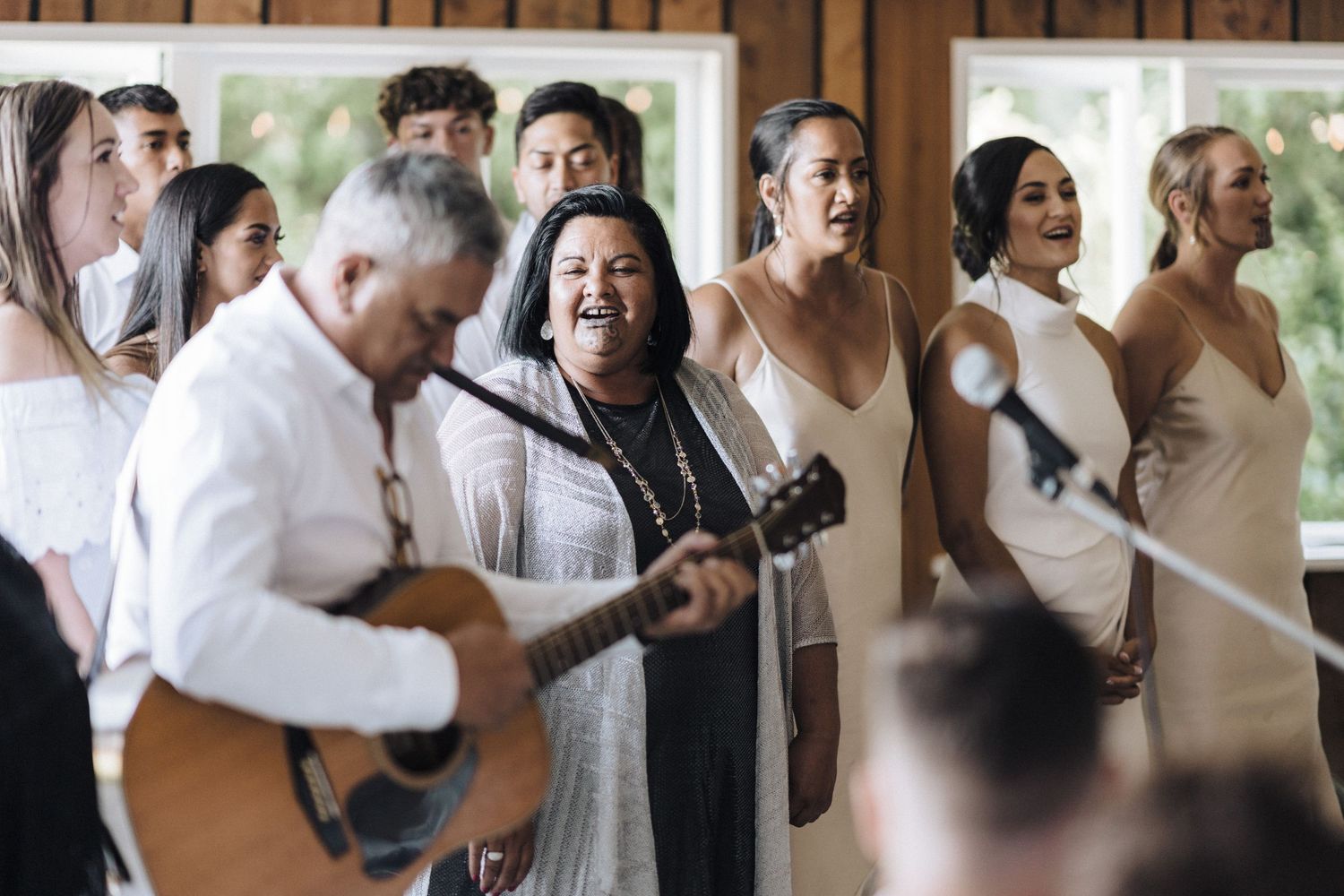 Wedding celebration with live music performance and singing in a bright indoor venue.