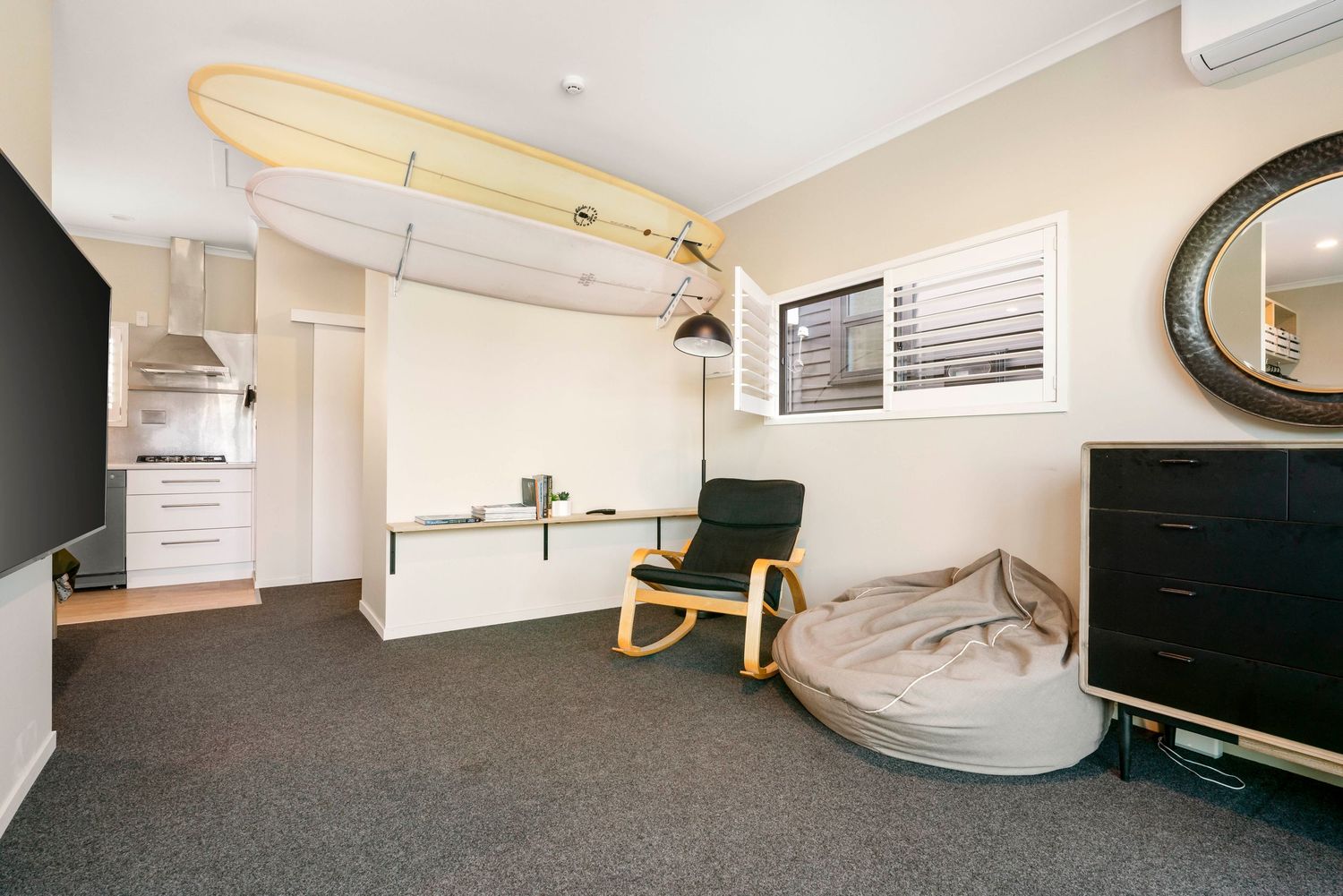 Spacious modern bedroom with neutral decor, built-in storage, and carpeted flooring.