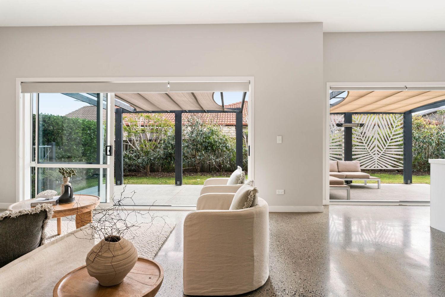 Contemporary living room with terrazzo floors and large sliding doors leading to garden terrace.