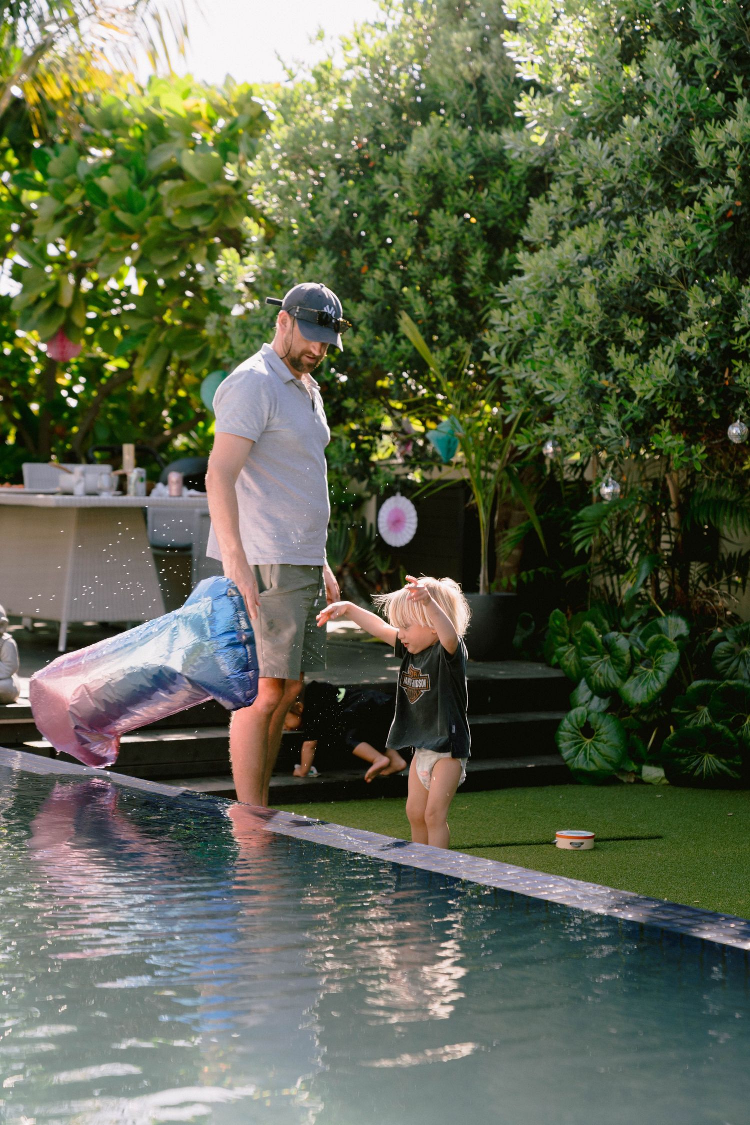 A sequence of photos showing someone jumping into a swimming pool surrounded by lush garden landscaping.
