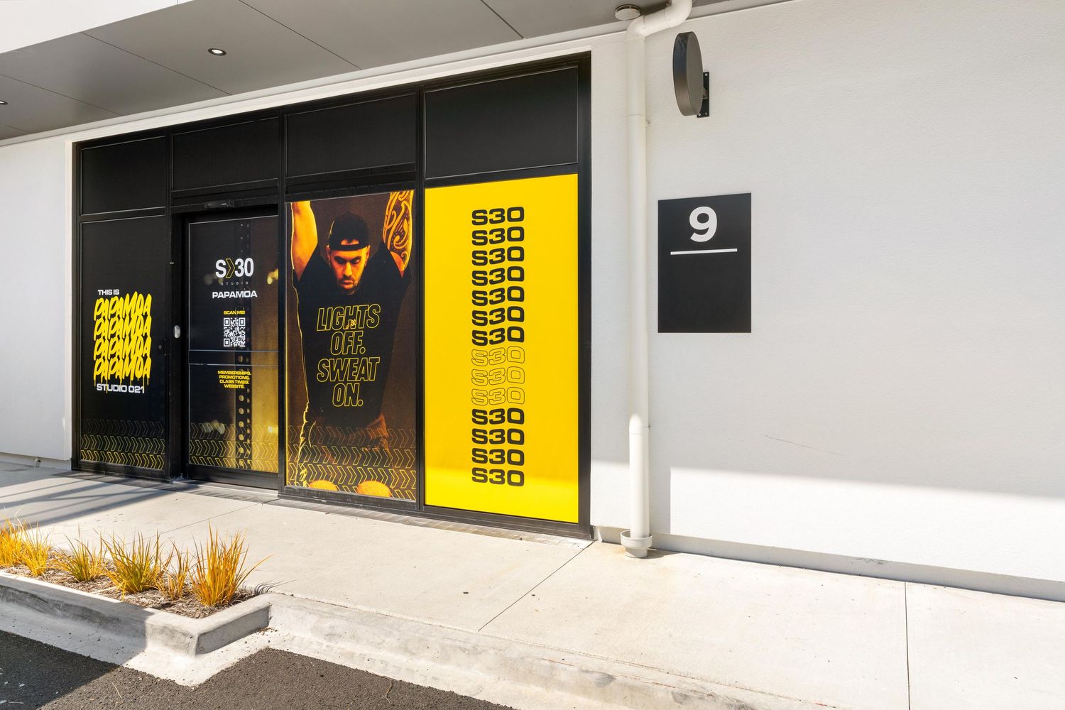 Minimalist storefront design with white walls and yellow accented signage elements.