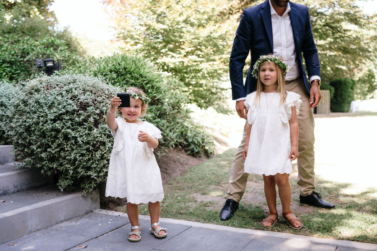 A wedding photography series showing details of white dresses and fancy shoes in an outdoor garden setting.