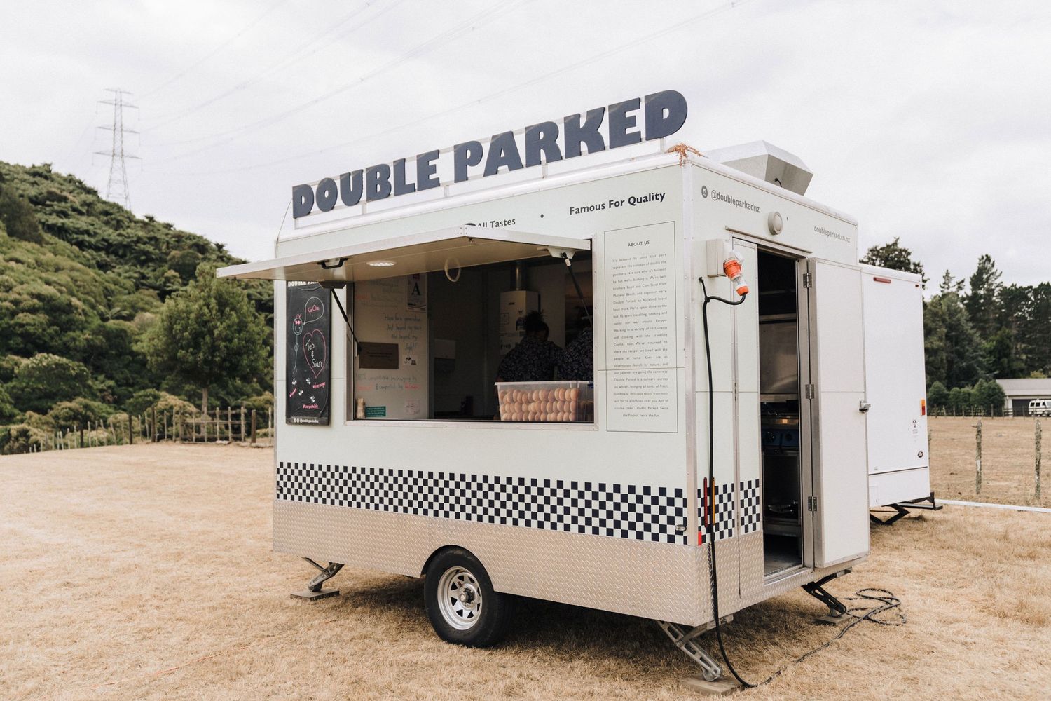 Exterior view of a white mobile retail trailer labeled 'Double Parked' with a checkered pattern.