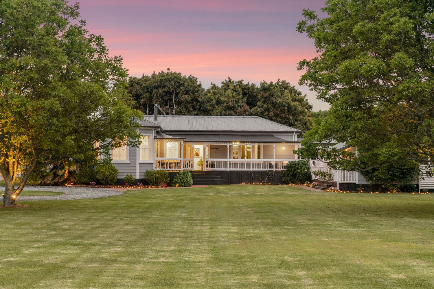 Panoramic views of a spacious green lawn surrounding a contemporary ranch-style home.