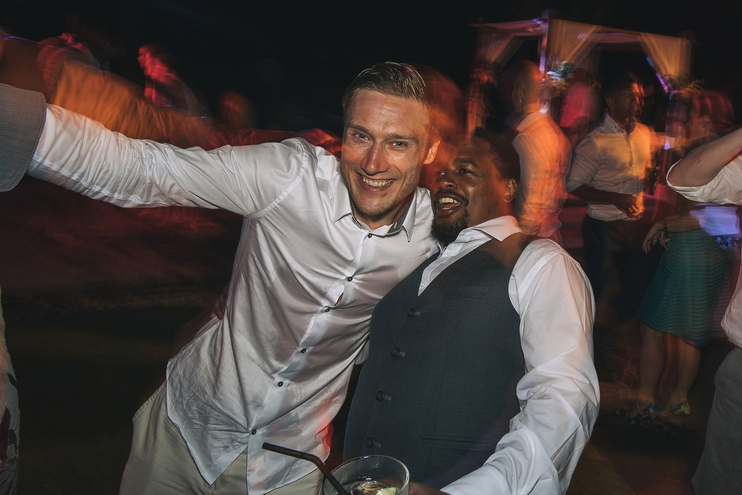 People dancing and celebrating at a lively wedding reception party.