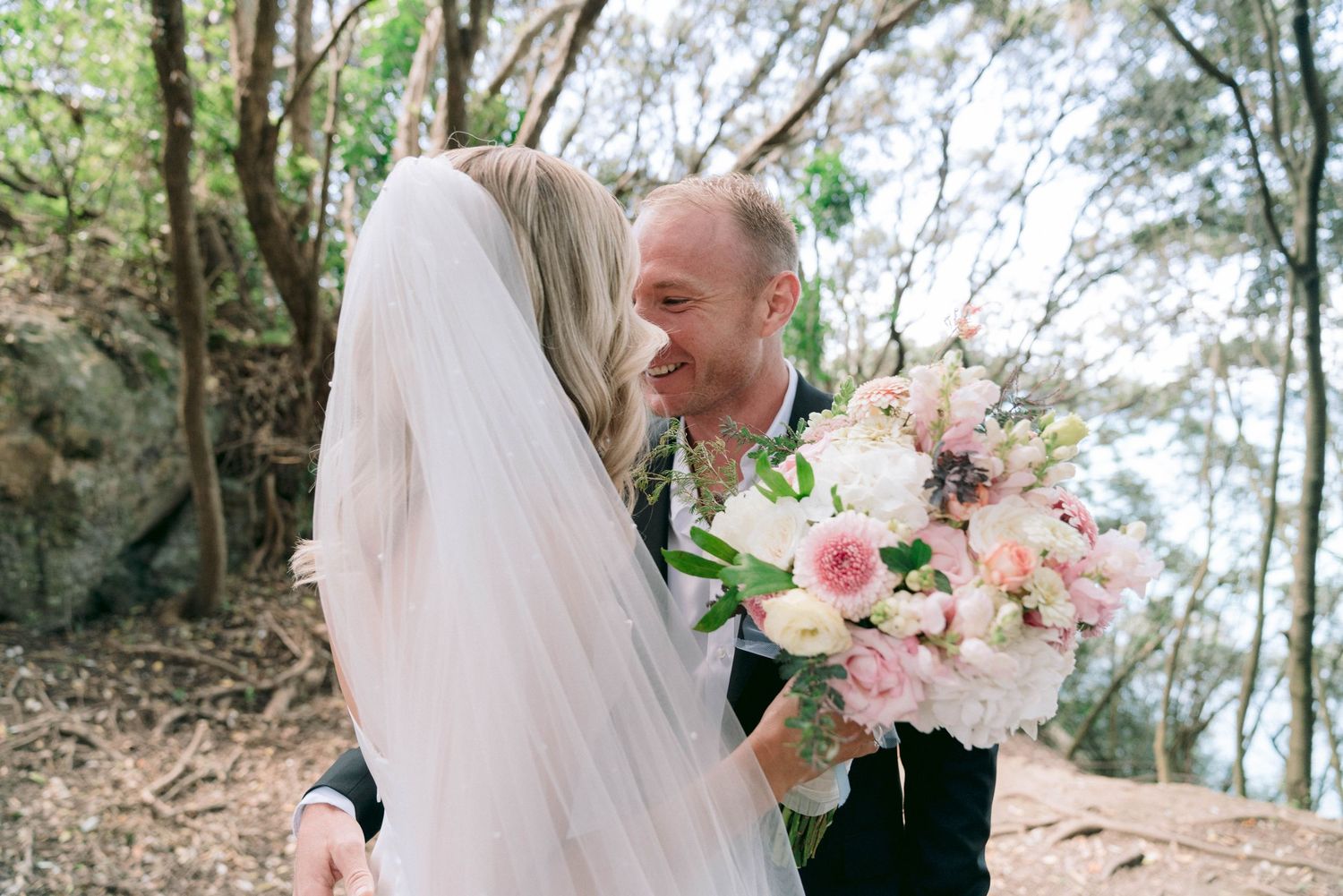 Romantic wedding photos captured in a lush garden setting with delicate pink floral bouquets.