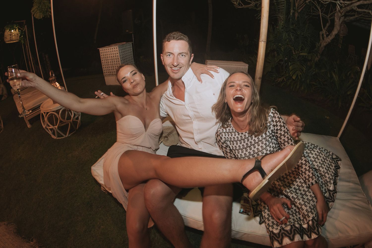 Wedding guests enjoying a fun candid moment on a swing at night.