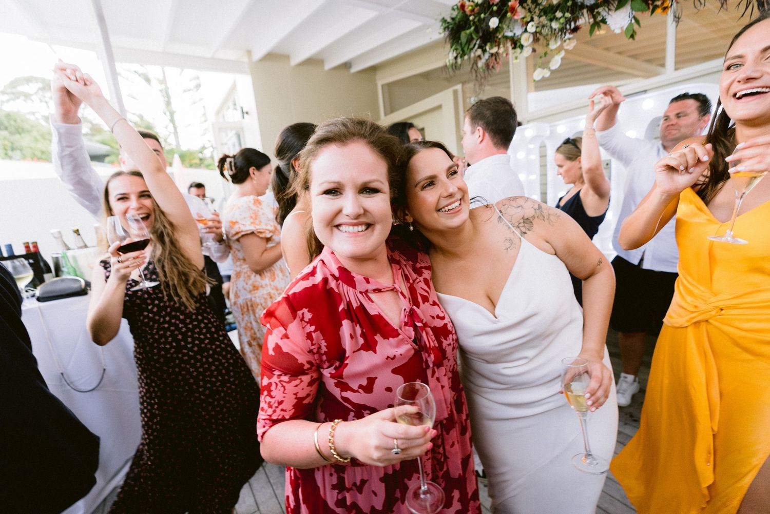 Wedding guests dancing and celebrating at a lively outdoor reception.