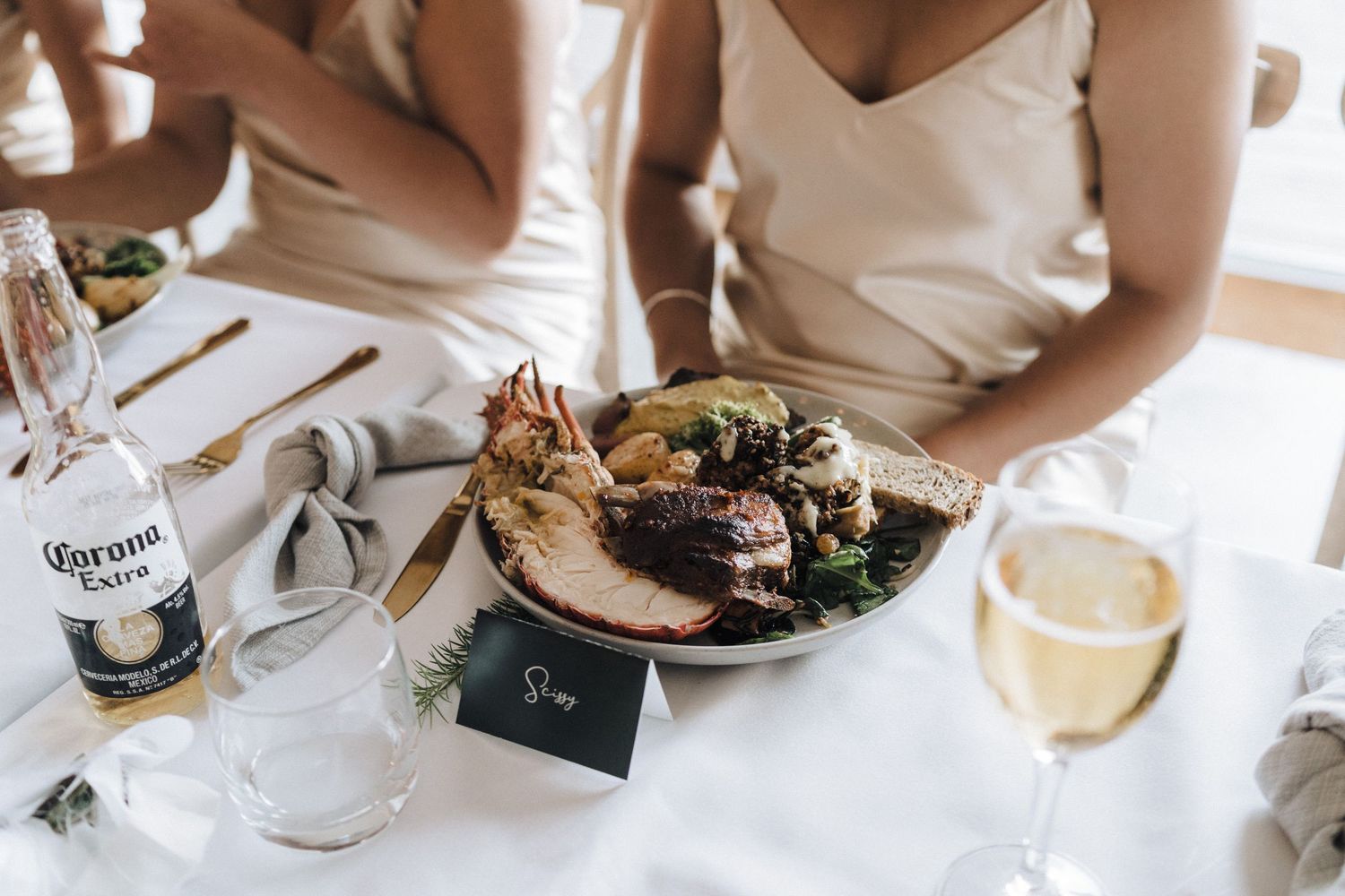 Elegant wedding table setting with plated meal and Corona beer.
