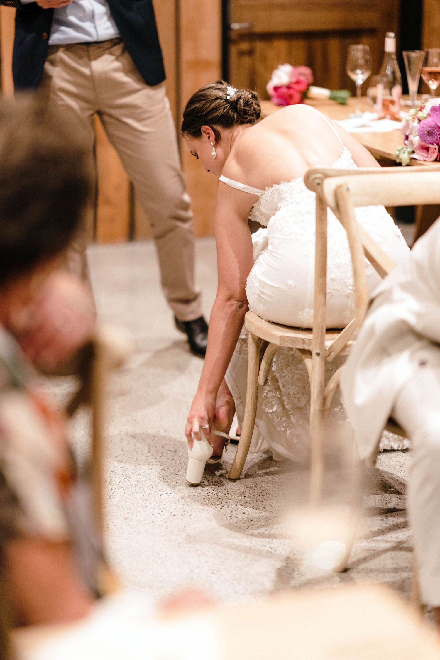White wedding dress detail and chairs at an indoor reception venue.