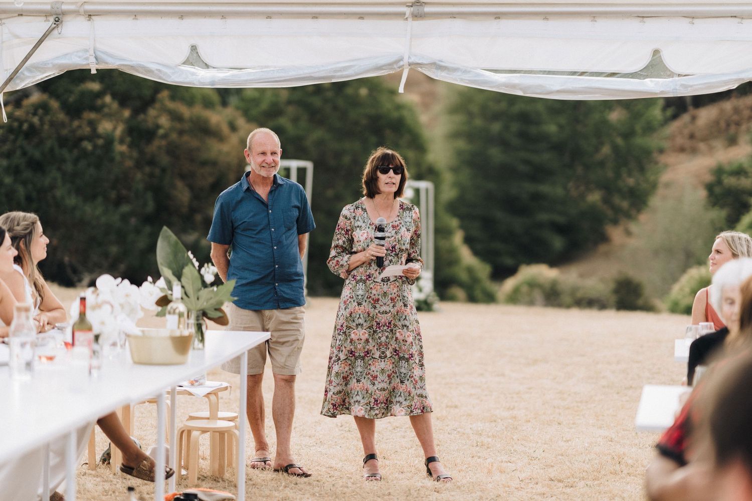 Guests enjoying an outdoor celebration under white canopies and decorative elements.