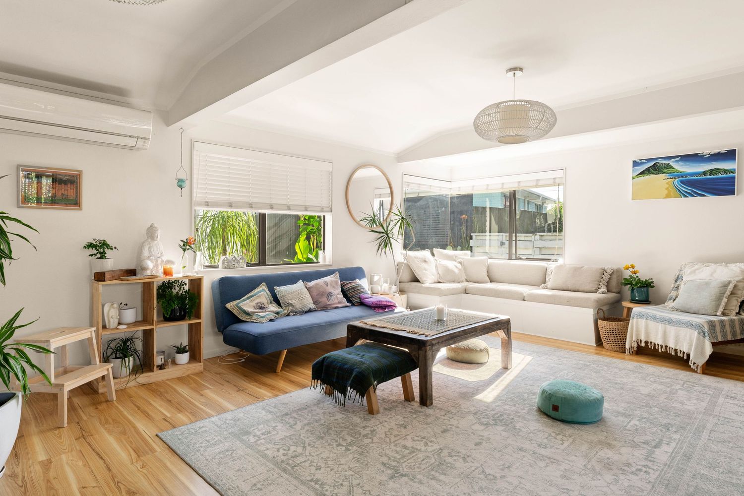Modern home interior showcasing hardwood floors, ample natural light, and minimalist furnishings in an open floor plan layout.