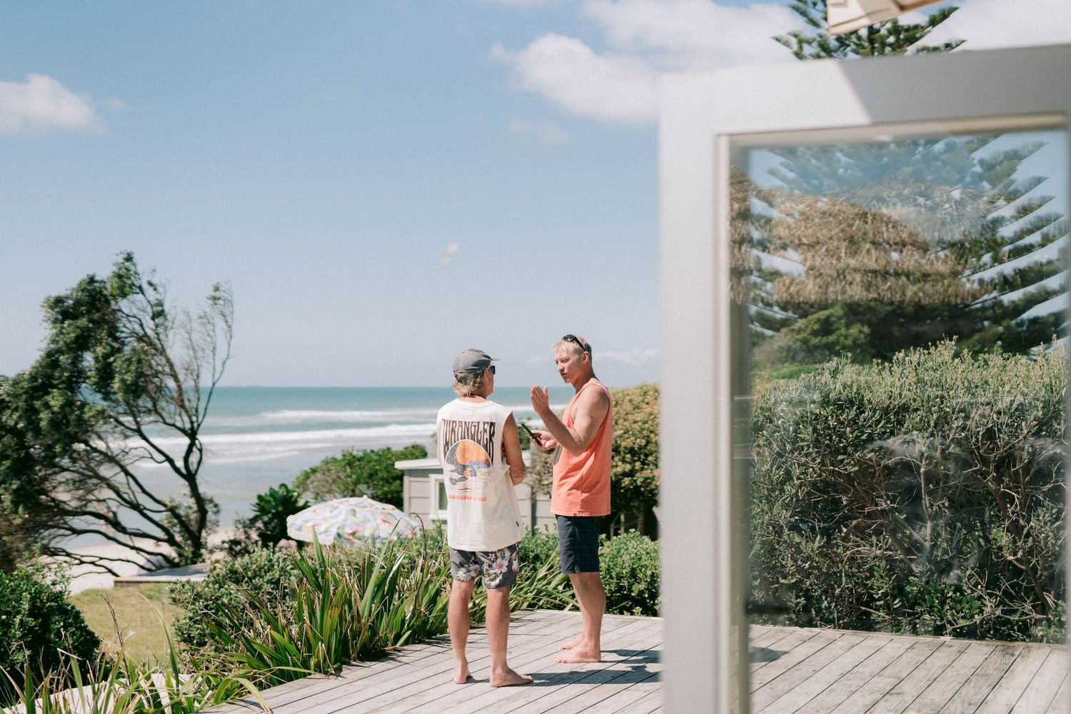 A scenic series of beach wedding moments with people gathered on a sandy shoreline under blue skies and ocean waves.