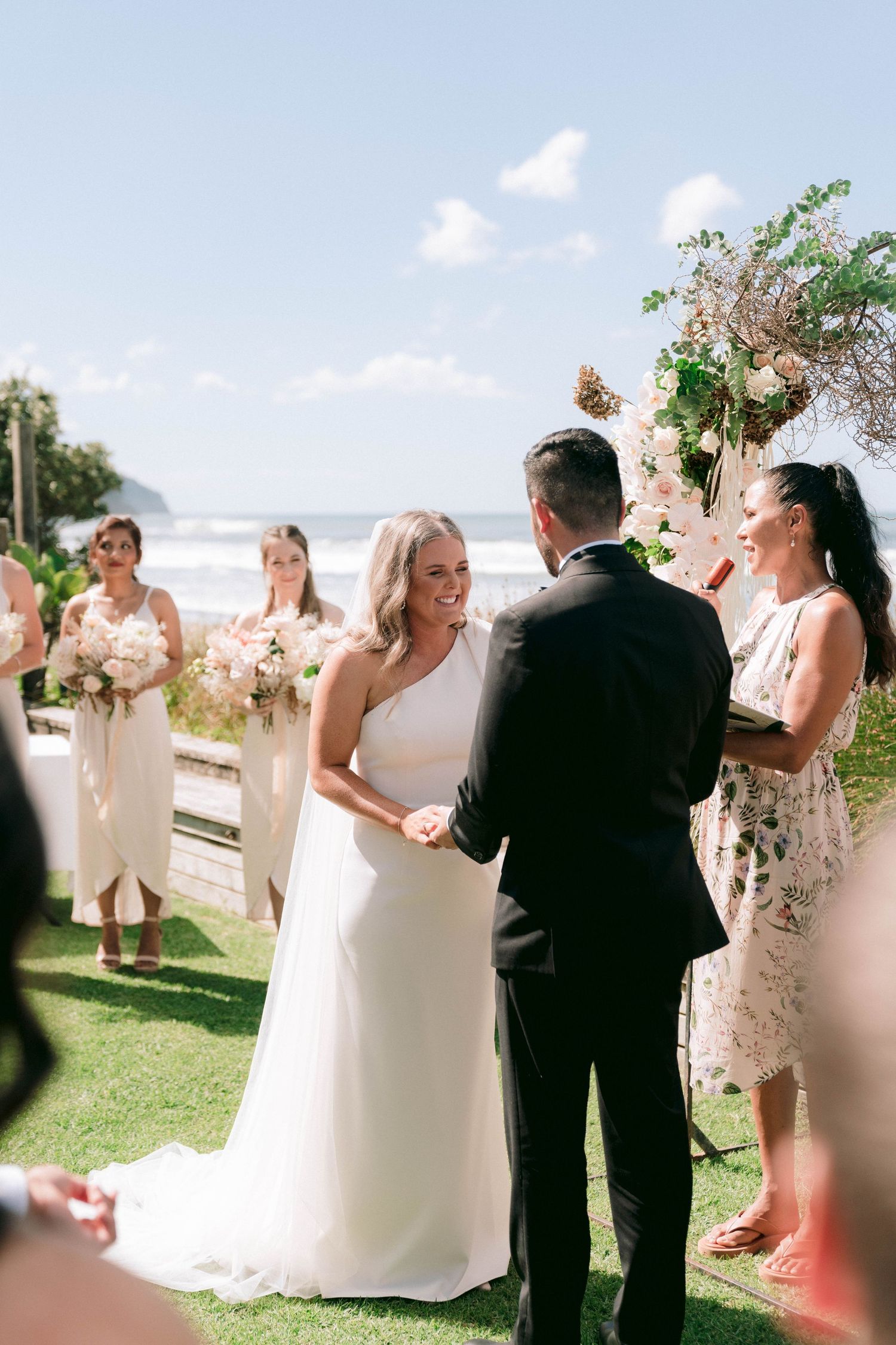 Wedding party celebrates with champagne toasts during an elegant outdoor ceremony on a sunny day.