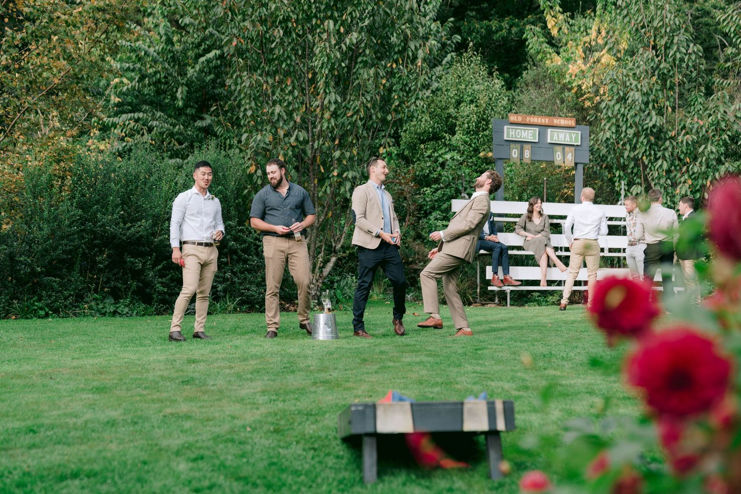 Garden wedding reception setup with rose bushes and outdoor seating arrangements.