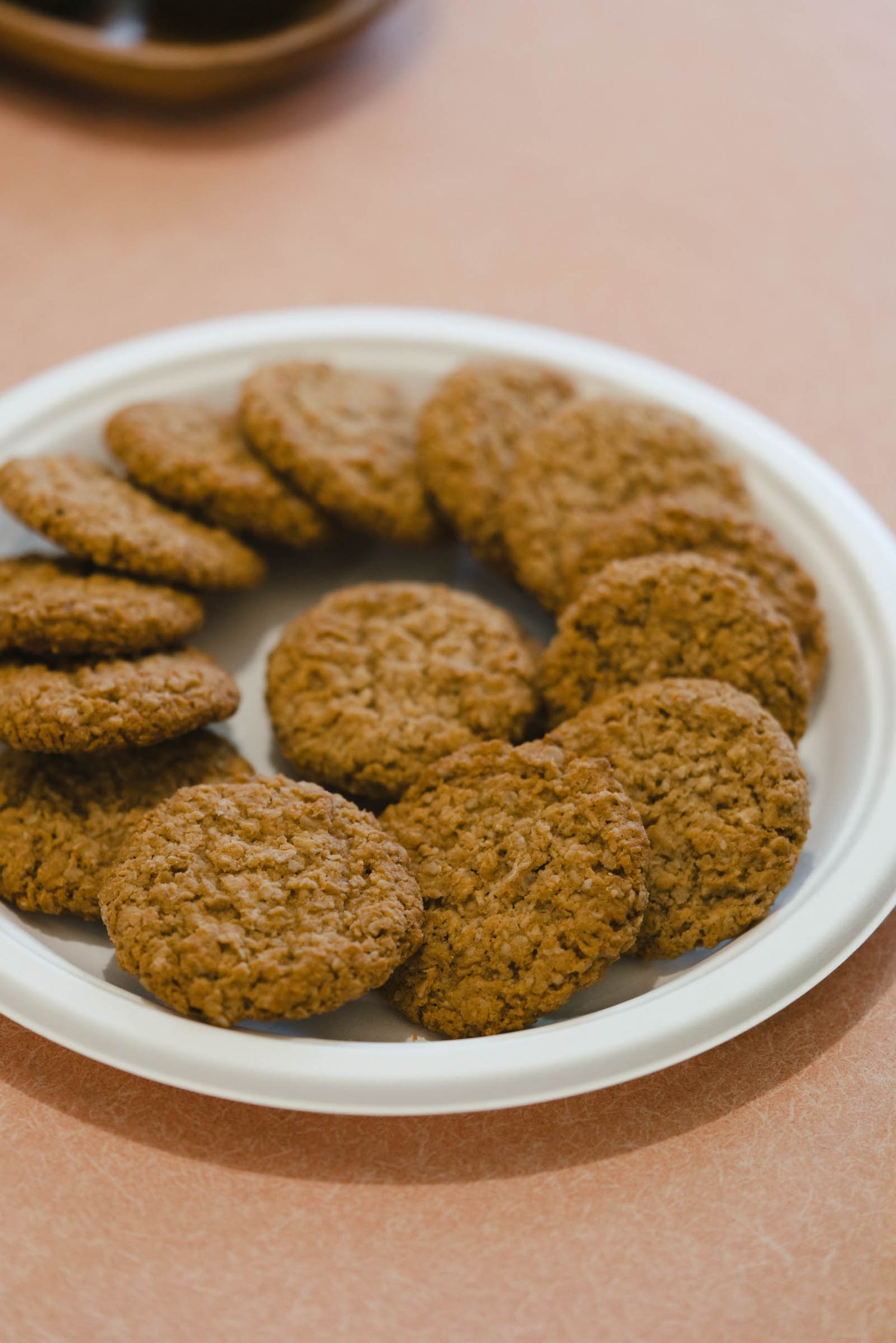 Golden brown cookies arranged in a circular pattern on a white plate.