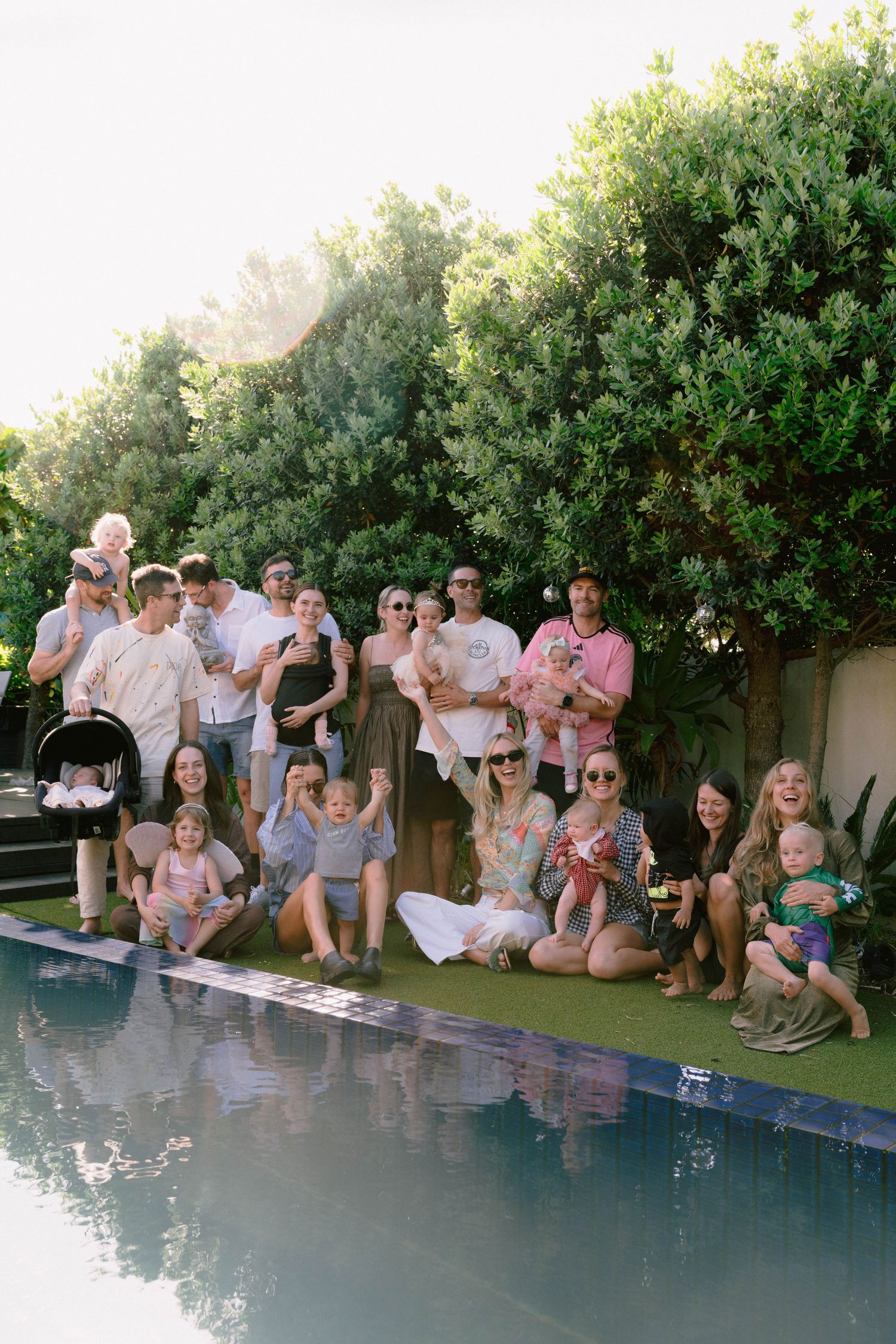 Friends gathered around a pool edge for a group photo during a summer party.