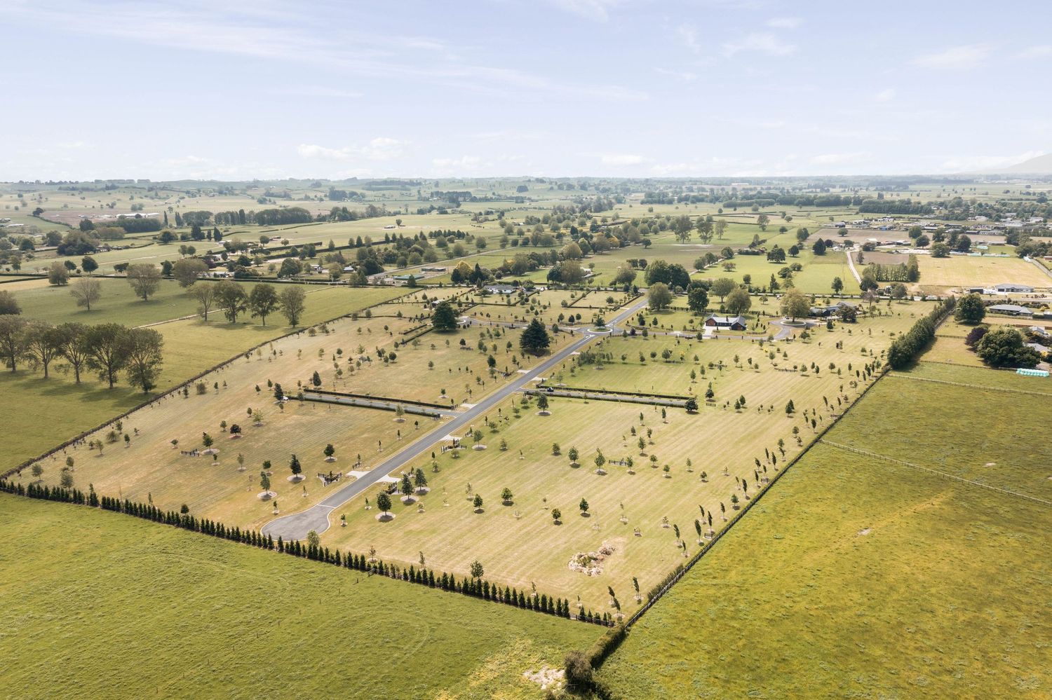 Drone shot of expansive equestrian facility with multiple riding arenas and paddocks.