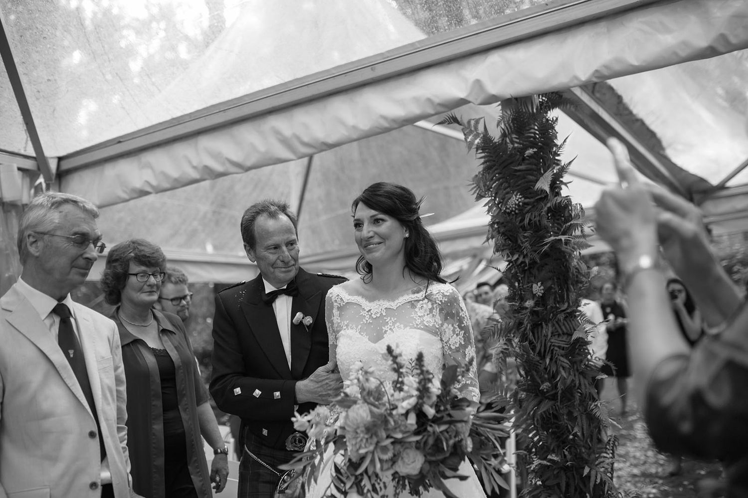 Small hors d'oeuvres are served to guests at a formal outdoor wedding reception.