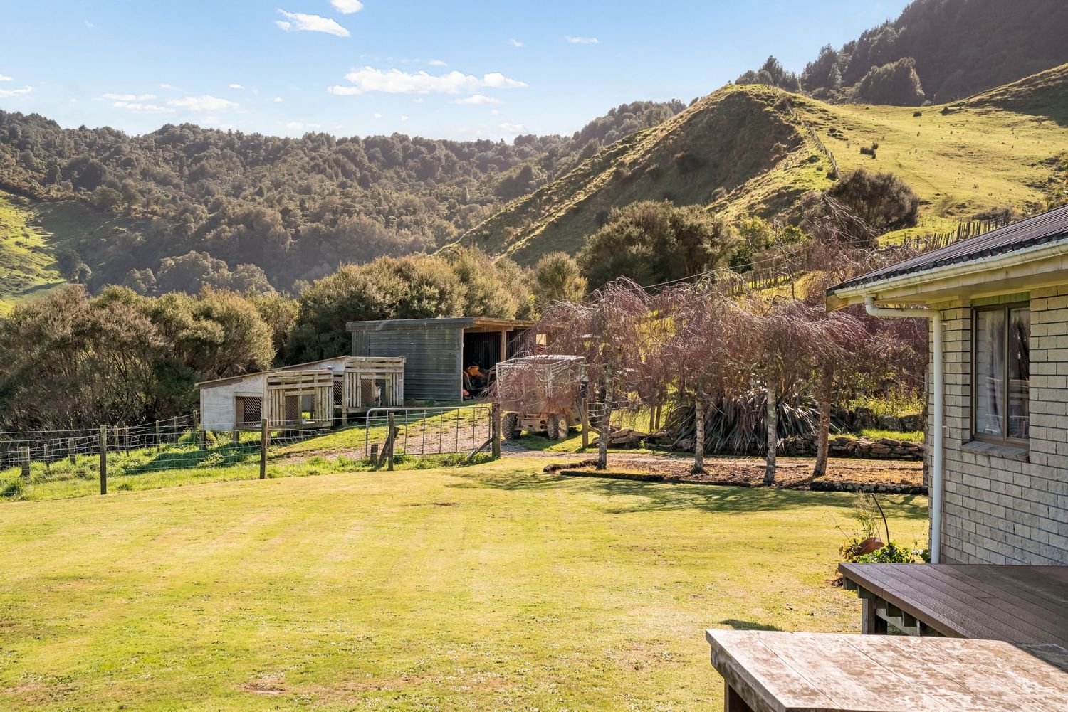 Brick buildings and green lawns surrounded by scenic mountain views in a peaceful valley setting.