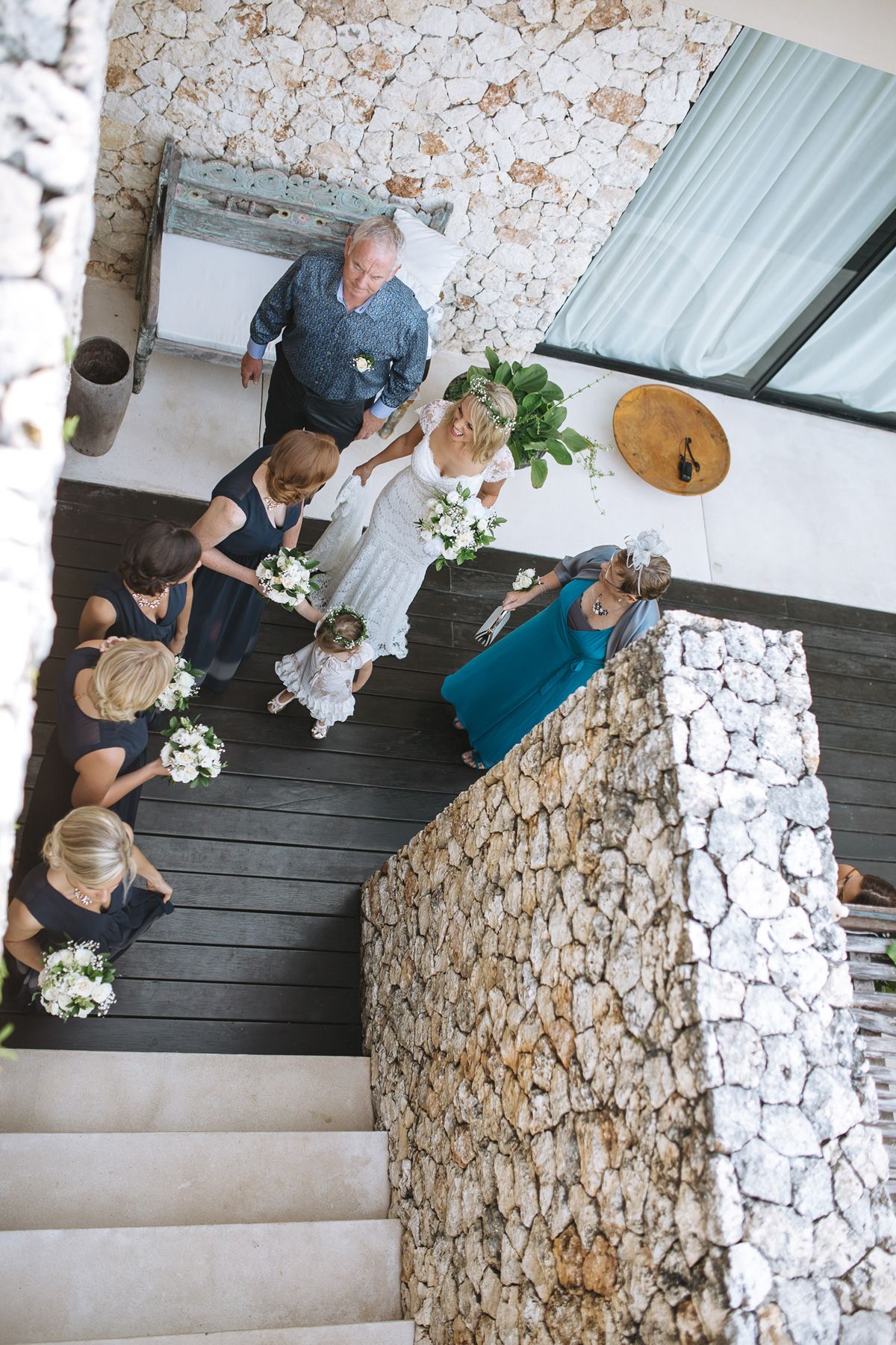A sequence of photos showing people ascending a stone-walled staircase during a wedding event.