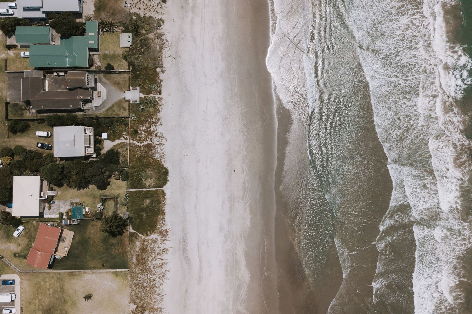 Aerial view of buildings and roads along a shoreline impacted by storm surge and coastal flooding.