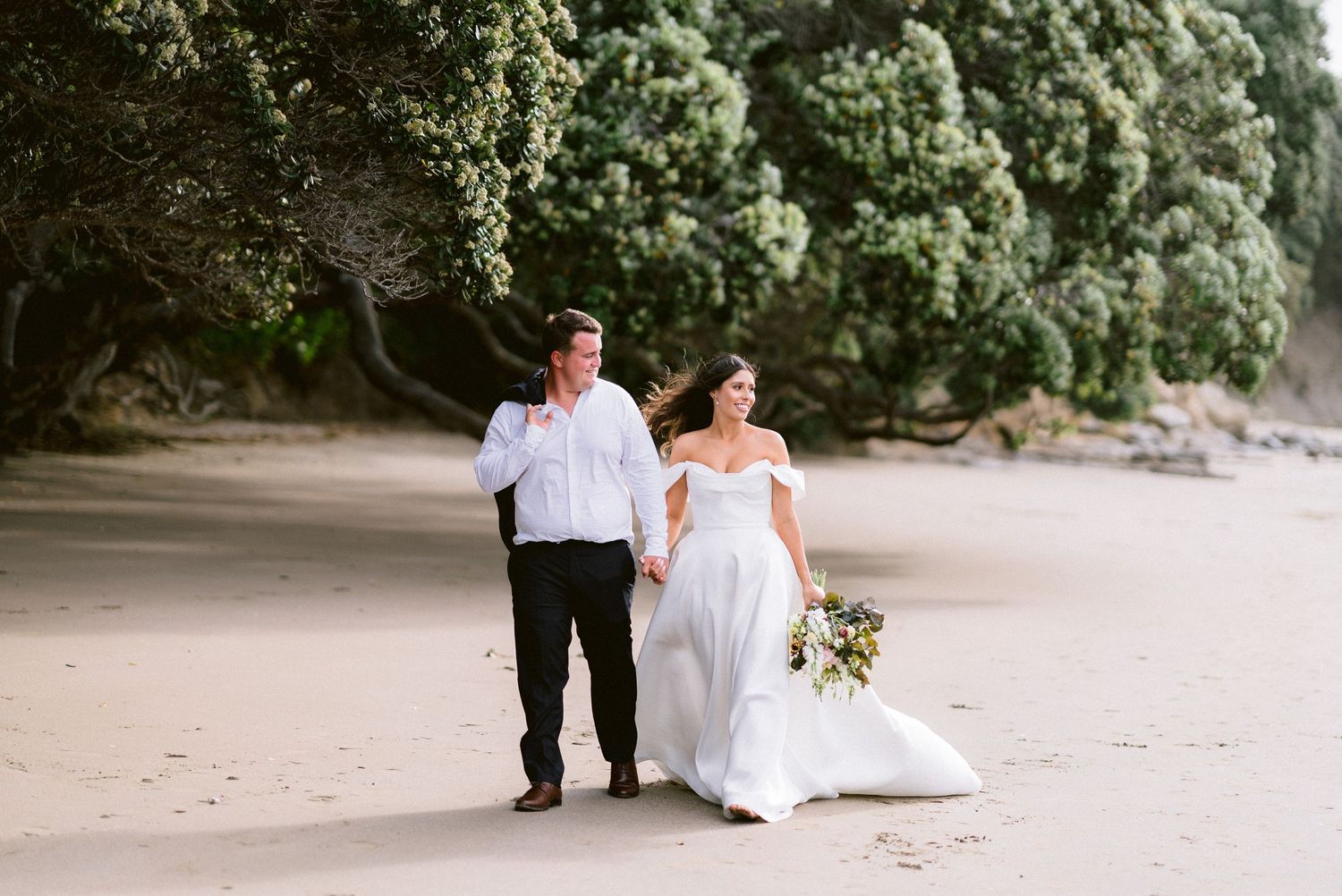 A beachside wedding moment captured with natural foliage in the background.