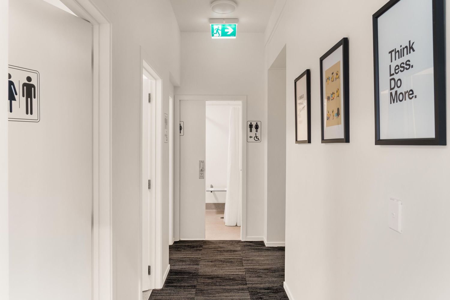 Clean white hallway with framed artwork and modern interior design elements.