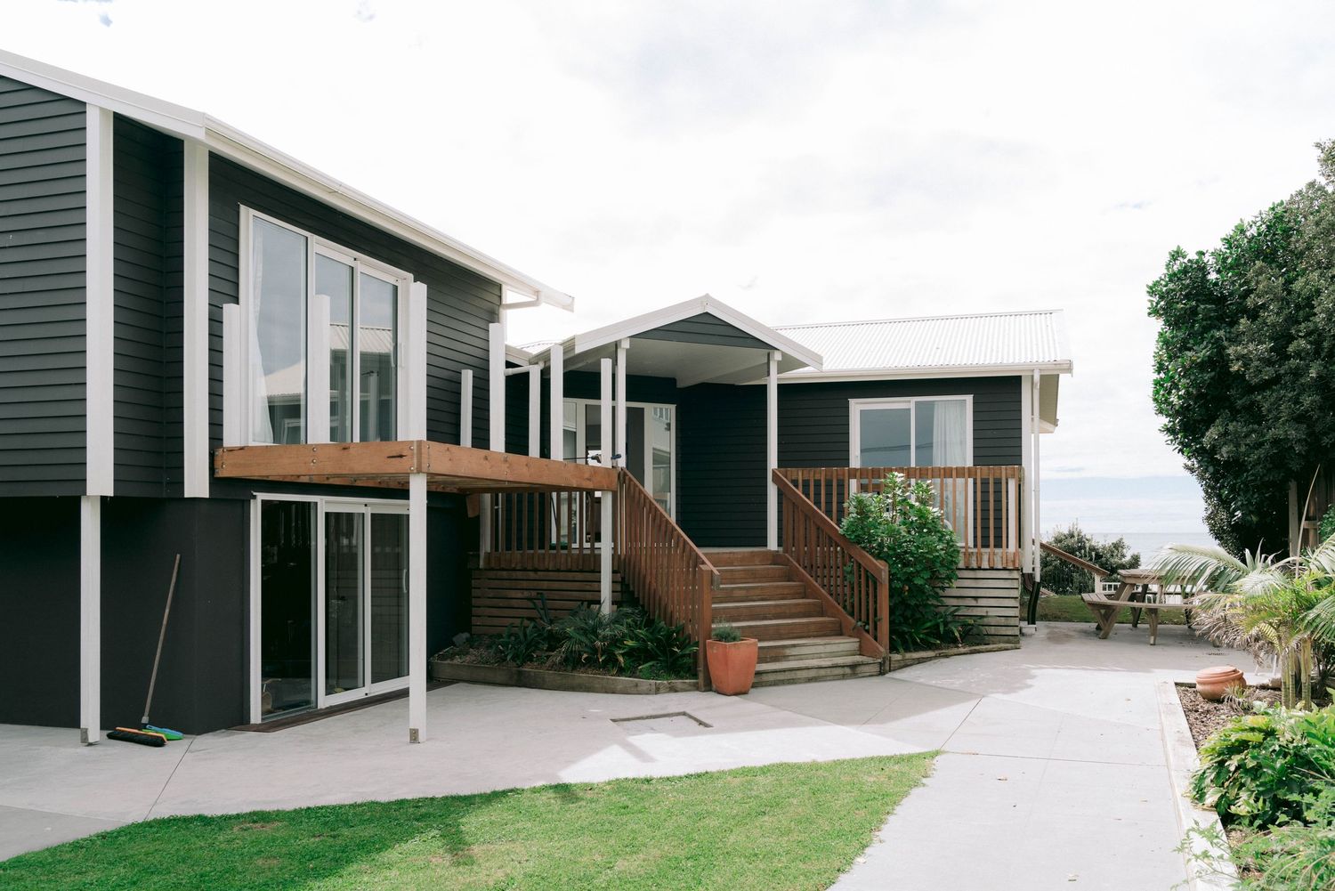 Modern modular home design with dark wood siding and large windows showcases contemporary architecture.