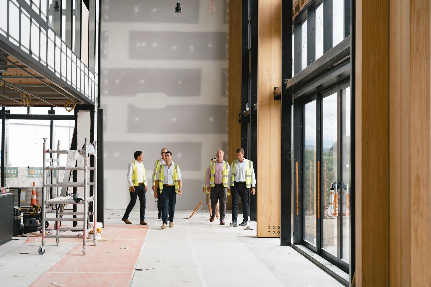 Interior view of a modern office space with glass windows and concrete floors.