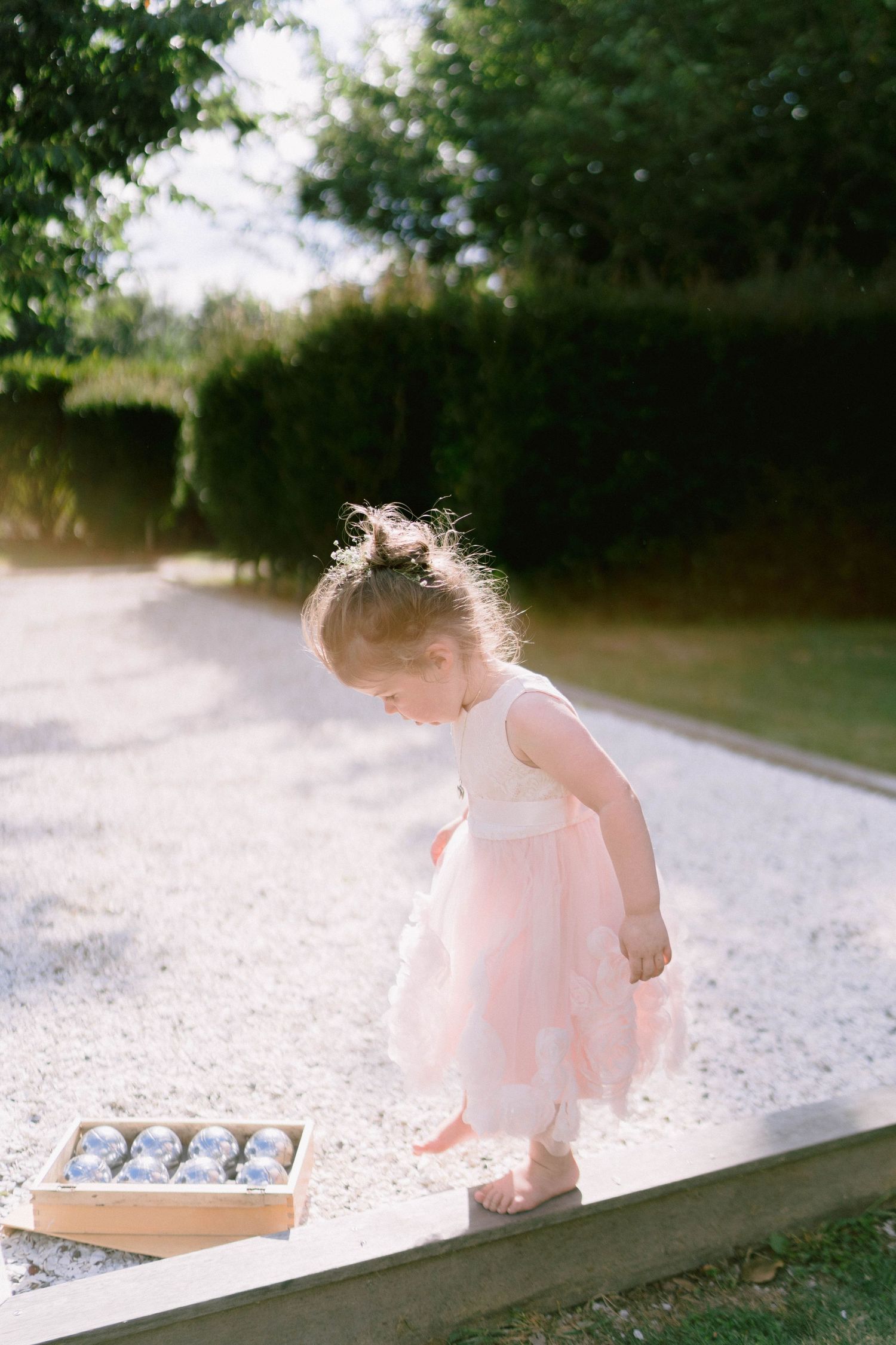A dreamy sunlit scene of a delicate pink dress in an outdoor setting.