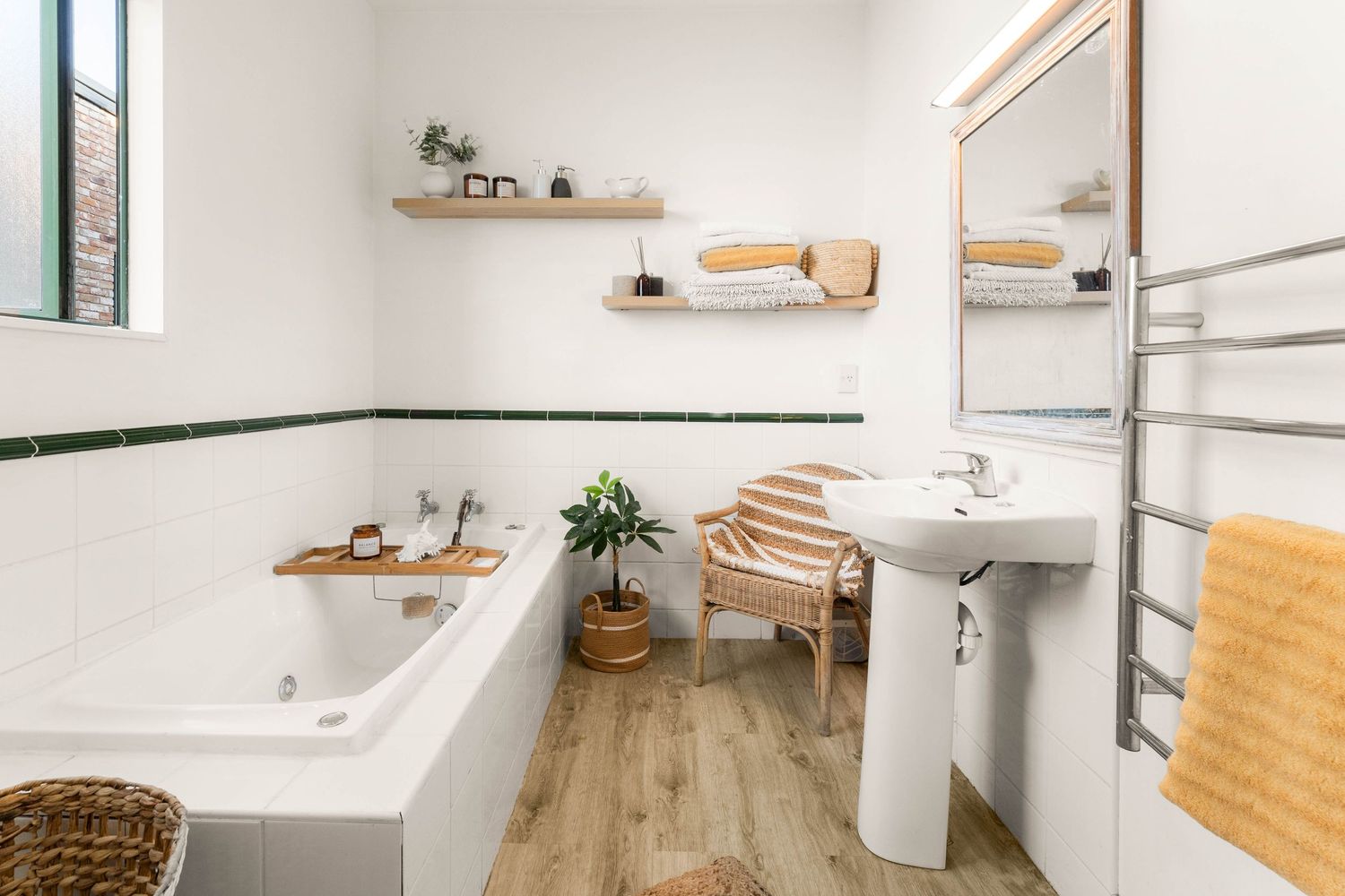 Bright bathroom interior with wooden shelves, white fixtures, and natural wood flooring.