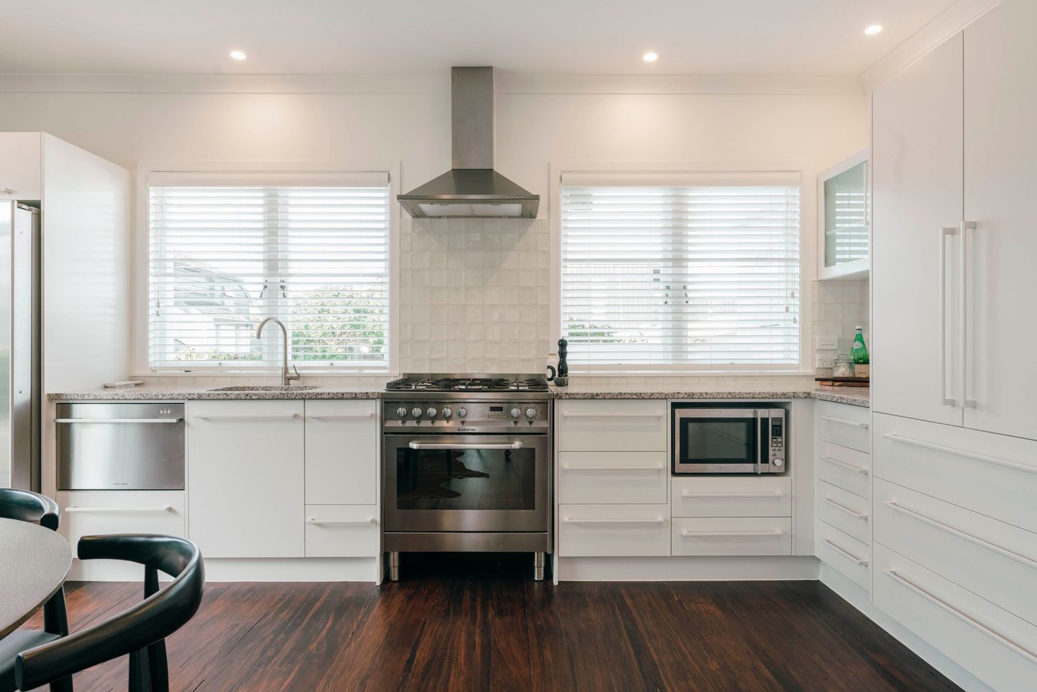 Modern white kitchen with stainless steel appliances and sleek cabinetry.