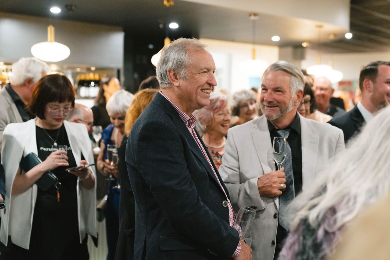 Guests mingling and socializing at an elegant indoor reception or party.