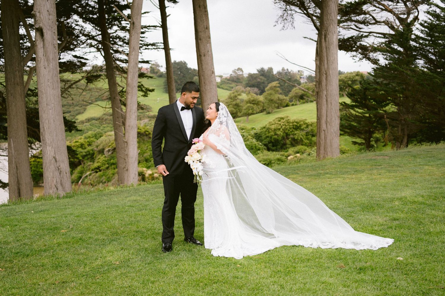 Bride and groom portrait session in natural outdoor setting with tall trees.