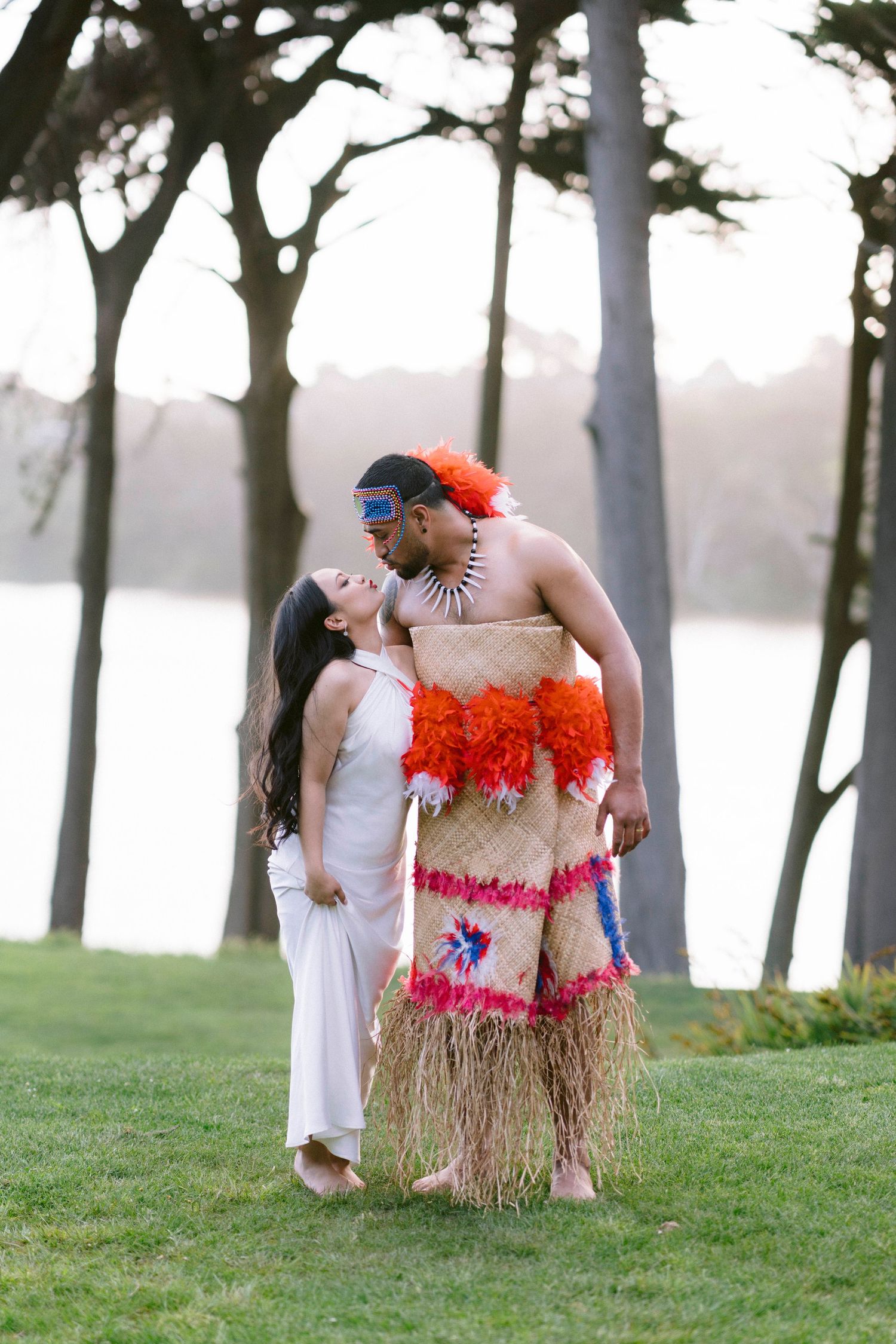 Cultural wedding photo with traditional Pacific Islander attire against misty treeline.